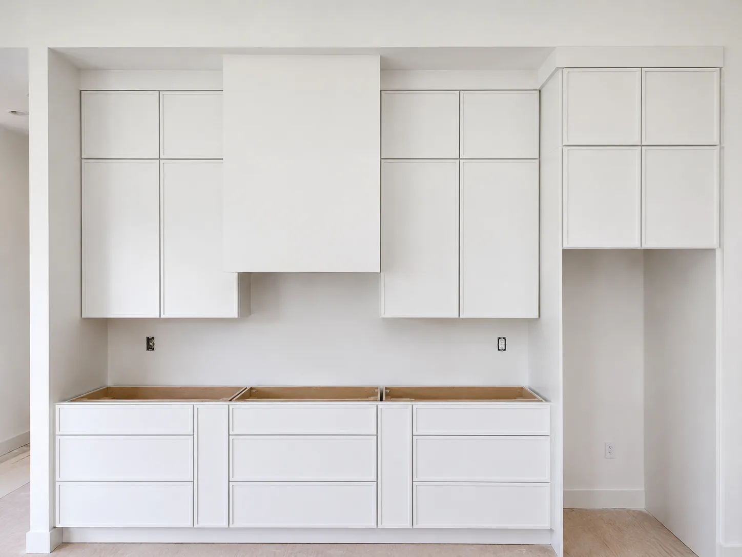 Sarasota kitchen replacement progress with white cabinetry and hood surround before countertop and backsplash completion
