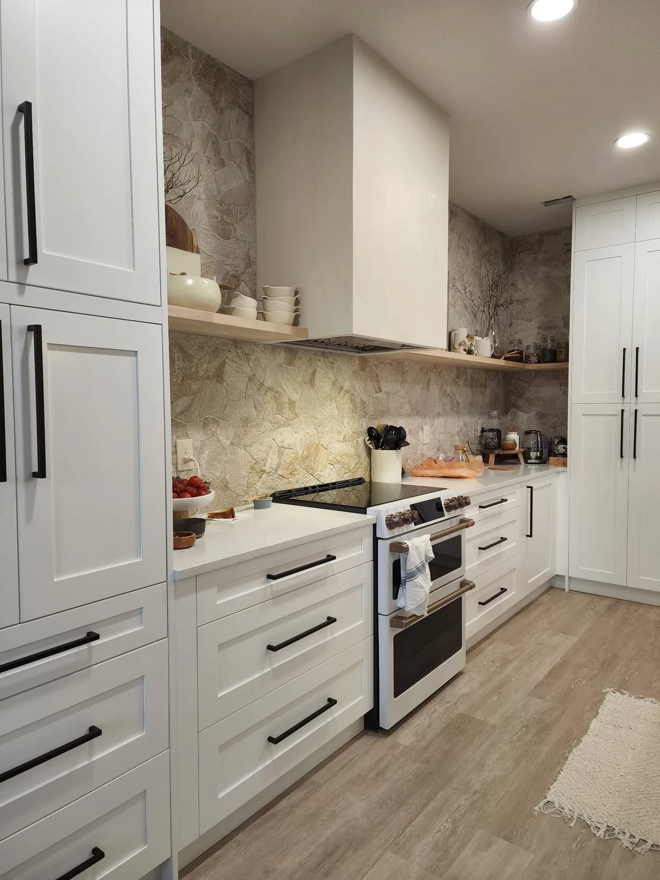 Finished Sarasota kitchen replacement with white cabinets, black hardware, countertop, and stone-look backsplash