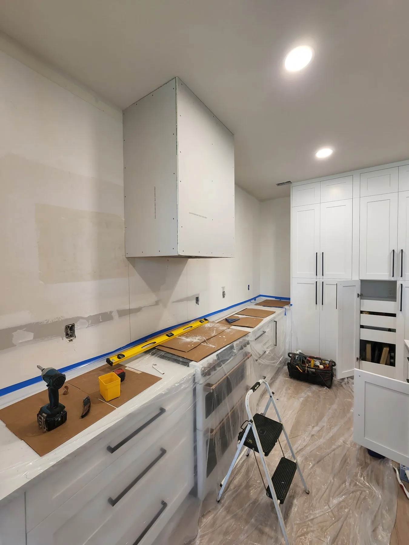 Sarasota kitchen replacement progress with white cabinets, range wall preparation, and black hardware